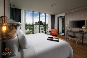 河內的住宿－Aurora Premium - A Lifestyle Hotel，酒店客房设有白色的床和大窗户。