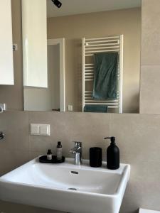 lavabo blanco en el baño con espejo en Terrace Flair, en Viena