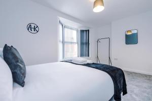 a white bedroom with a bed and a window at Cosy 3 bed 3 bath house - Central Liverpool -Self Check-In & Free Parking! in Liverpool