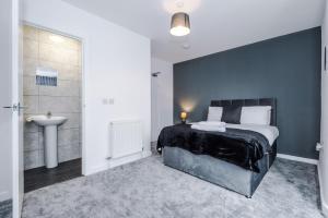 a bedroom with a bed and a bathroom with a sink at Cosy 3 bed 3 bath house - Central Liverpool -Self Check-In & Free Parking! in Liverpool