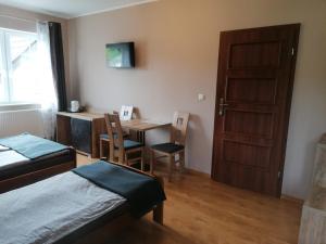 a room with a bed and a table and a door at Apartamenty Otylka in Wisełka