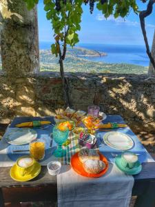 a table with plates of food on it with a view of the ocean at Il Castello di San Sergio in Centola