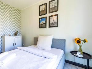 a bedroom with two beds and a vase with flowers at Apartament Przystań Iława Yellow in Iława