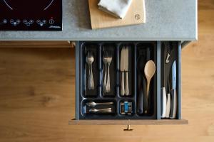 a drawer filled with utensils on top of a counter at FREIgeist Homes - Serviced Apartments in Göttingen