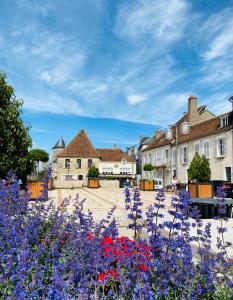 vistas a una ciudad con flores en el primer plano en La Place B&B, en Sancerre