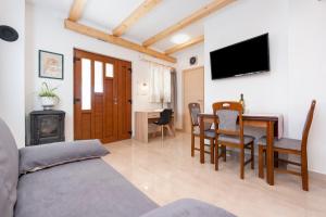 a living room with a dining room table and a television at Casetta in campagna in Rovinj