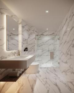een witte badkamer met een wastafel en een spiegel bij Leon Lasalle Hotel and Residences in Bangkok