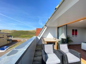 een balkon met 2 stoelen en een tafel bij Callantsoger Staete A304 in Callantsoog