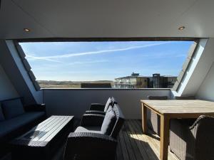een balkon met een tafel en stoelen en een raam bij Callantsoger Staete A304 in Callantsoog