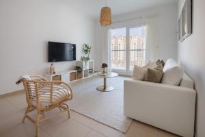 - un salon avec un canapé blanc et une télévision dans l'établissement Frank Porter - Grand Horizon, à Dubaï