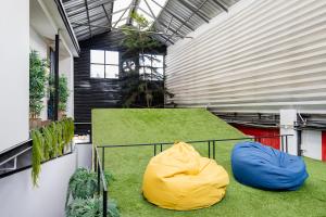 チェンライにあるSpinomad hostelの青と黄色のビーンバッグが2つ置かれたバルコニー