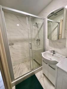 ein Bad mit einer Dusche und einem Waschbecken in der Unterkunft Apartmant in Kyiv for you in Kiew