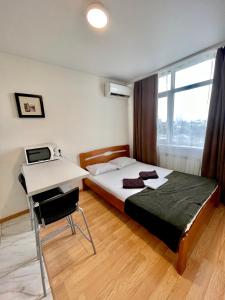 a bedroom with a bed and a desk with a laptop at Apartmant in Kyiv for you in Kyiv