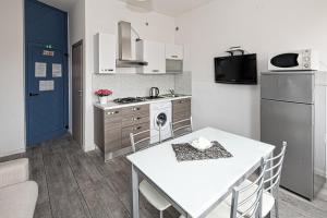 uma cozinha com uma mesa branca, um fogão e um frigorífico em Residence Rimini Mare em Rimini