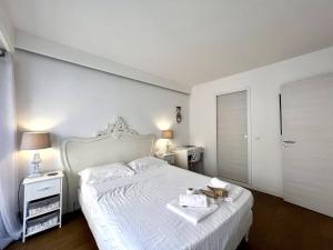 ein Schlafzimmer mit einem weißen Bett mit einem ausgestopften Tier darauf in der Unterkunft "La Résidence du Casino" Plein centre, Accès Mer in Menton