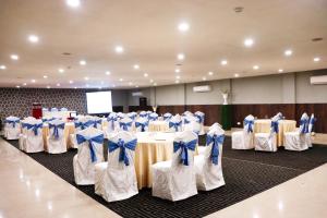 a room with tables and chairs with blue bows at Hotel Clarks Collection Bhavnagar in Bhavnagar