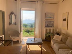 sala de estar con sofá, mesa y ventana en Villa Valle dei Fiori, en Mulazzo