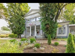 a large white house with a tree in front of it at Valensija - Cute cottage in big yard in Jūrmala