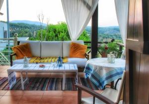 a living room with a couch and two tables at - Ta Petrina - Traditional Stone-built Villa in Agios Nikolaos