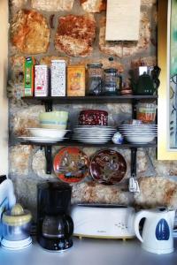 a shelf with plates and dishes on a wall at - Ta Petrina - Traditional Stone-built Villa in Agios Nikolaos