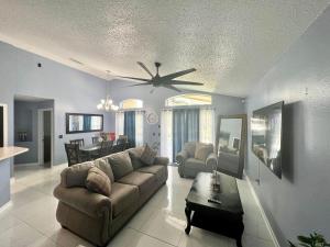 uma sala de estar com um sofá e uma ventoinha de tecto em Grand Family Superior 4BR House near Disney Parks em Davenport