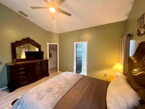 um quarto com uma cama grande e um espelho em Grand Family Superior 4BR House near Disney Parks em Davenport