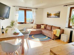 ein Wohnzimmer mit einem Sofa und einem Tisch in der Unterkunft Ferienwohnung Sonnenblick in Edersee
