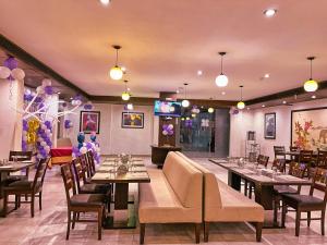 a restaurant with tables and chairs and purple balloons at Hotel Clarks Collection Bhavnagar in Bhavnagar