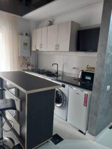 a kitchen with a counter top and a dishwasher at Apartament 2 dormitoare și living bloc nou in Năvodari
