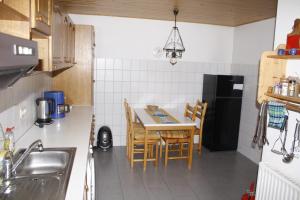 a kitchen with a table and chairs and a refrigerator at Ferienwohnung Weilerbach in Weilerbach