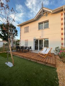 une terrasse en bois devant une maison dans l'établissement la villa d'Irissou YourHostHelper, à Andernos-les-Bains