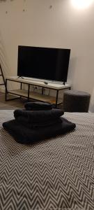 a room with a television and a bed with black towels at Stuck Ferienwohnungen in Cottbus