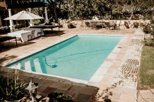a swimming pool in a yard with a table at Swartvlei Guest Farm in Sedgefield