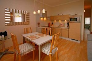 a kitchen and dining room with a table and chairs at SW6 Haus Wittsand in Spieka-Neufeld