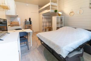 1 dormitorio con cama, escritorio y cocina en CABANA & Perle de Lac - Proche du Lac, en Sévrier