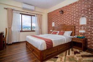 a bedroom with a bed with a brick wall at Madhuban Hotel in Kathmandu