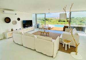 un soggiorno con divano bianco e TV di Villa Possanco, Comporta beach villa a Comporta