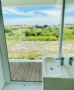 a bathroom with a sink and a large window at Villa Possanco, Comporta beach villa in Comporta