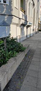 a sidewalk in front of a building with plants at Stuck Ferienwohnungen in Cottbus