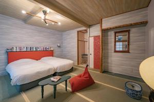 ein Schlafzimmer mit einem großen Bett und einem roten Stuhl in der Unterkunft 湯河原温泉 夢十夜 in Yugawara
