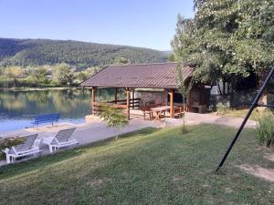 een paviljoen met een tafel en stoelen naast een meer bij Villa Giulia in Bihać