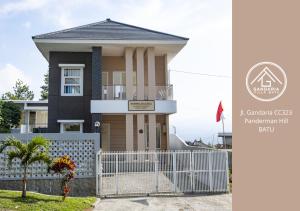 una casa con una recinzione bianca davanti di Gandaria Villa Batu a Batu