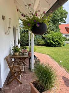 a patio with a table and chairs and flowers at Ruegen_Fewo 155 in Veikvitz