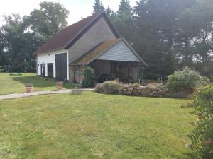 a small white house with a grass yard at Ruegen_Fewo 155 in Veikvitz +32 photos
