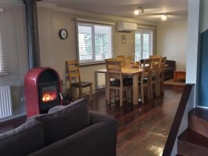 a living room with a table and a fireplace at Beautiful Dutch Barn style country house in Merrijig (base of Mt Buller). in Merrijig