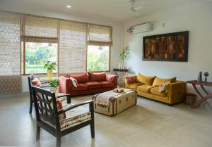 a living room with couches and chairs and windows at ili-ah ki in Dimāpur