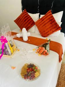 a white bed with a plate of food on it at Jnc Lodge in Richards Bay