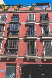 ein rotes Backsteingebäude mit Balkonen an der Seite in der Unterkunft Céntrico Apartamento en Calle Carreteria - Malaga in Málaga