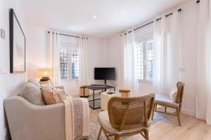 a living room with a couch and chairs and a tv at Genteel Home Aire in Seville