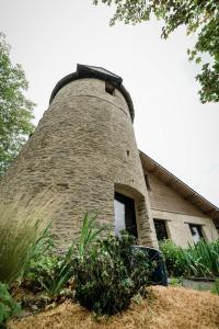 una casa con una chimenea de ladrillo encima en Le Moulin d' Erée, gîte Insolite de charme, en Soudan